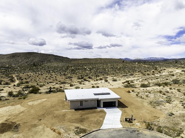 drone / aerial view featuring a rural view, a mountain view, and a desert view