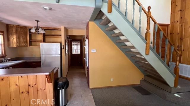 33411 Weeping Willow Dr, Green Valley Lake, CA 92341 - kitchen featuring freestanding refrigerator, light tile patterned floors, a sink, a chandelier, and decorative light fixtures