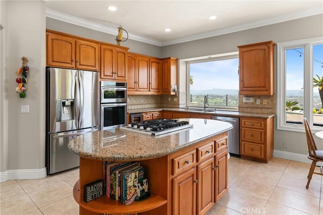 kitchen with brown cabinetry, a sink, appliances with stainless steel finishes, and light tile patterned floors