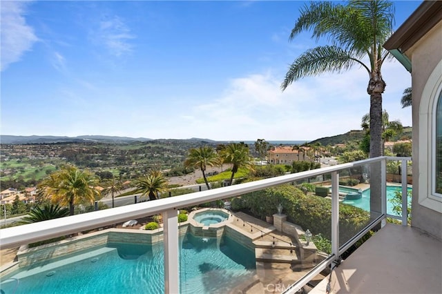 view of swimming pool with a pool with connected hot tub and a mountain view