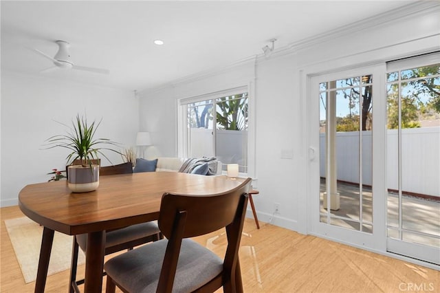 dining space featuring plenty of natural light, ornamental molding, and light wood finished floors