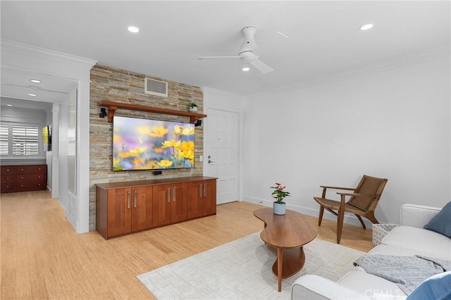 living room with light wood-style floors, crown molding, and visible vents