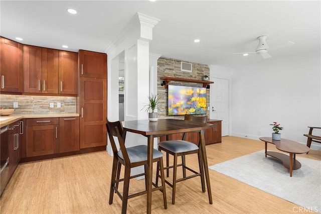kitchen with decorative backsplash, ornamental molding, light wood-type flooring, and visible vents