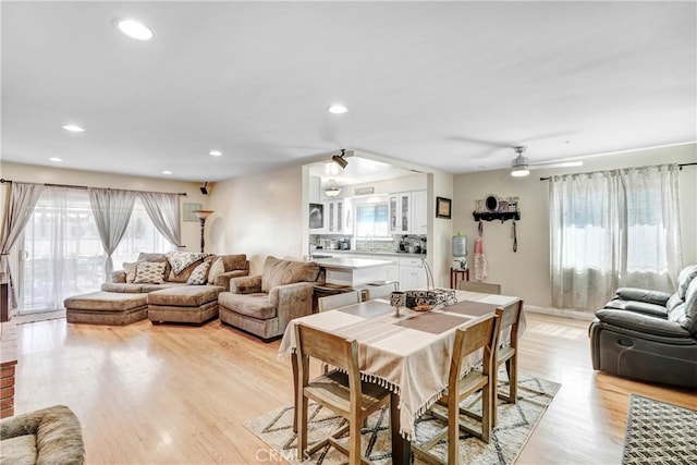 dining room with recessed lighting, a ceiling fan, a wealth of natural light, and light wood-style floors