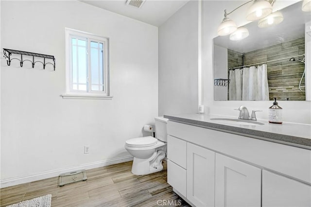 full bathroom with visible vents, vanity, wood finished floors, toilet, and a tile shower