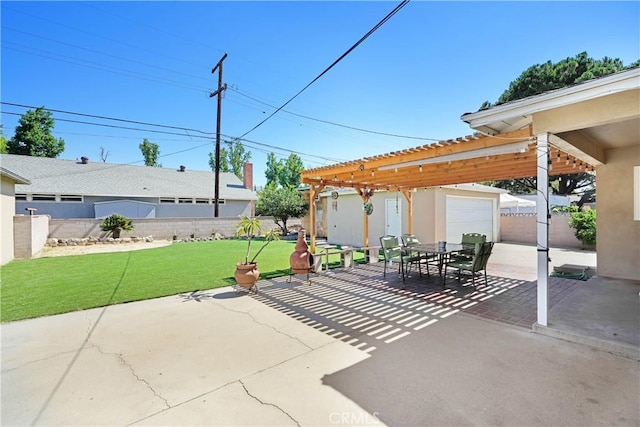 view of patio / terrace featuring fence, an outbuilding, outdoor dining space, and a garage