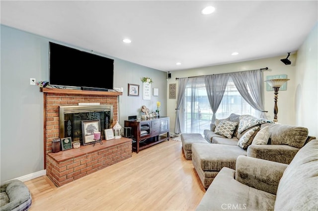 living room with recessed lighting, wood finished floors, and a fireplace
