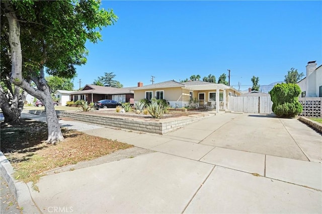 ranch-style house with fence and driveway