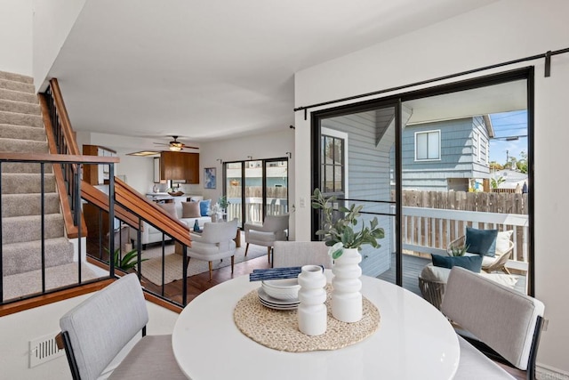 dining area with visible vents, ceiling fan, a wealth of natural light, and stairway