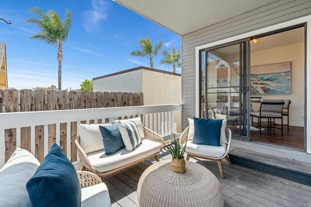 deck featuring outdoor lounge area and fence