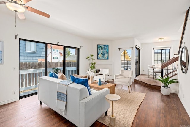 living room featuring baseboards, ceiling fan, and hardwood / wood-style floors
