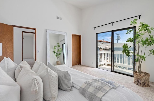 carpeted bedroom featuring visible vents, a towering ceiling, and access to outside