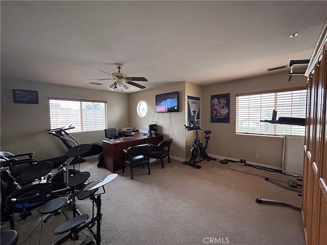 office space with carpet floors, ceiling fan, visible vents, and baseboards