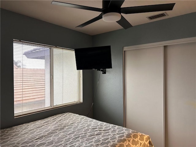 bedroom featuring multiple windows, a ceiling fan, a closet, and visible vents