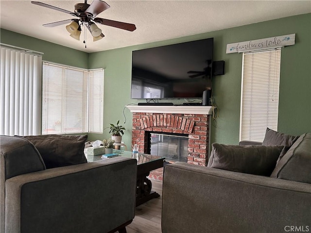 living room with ceiling fan, wood finished floors, and a fireplace