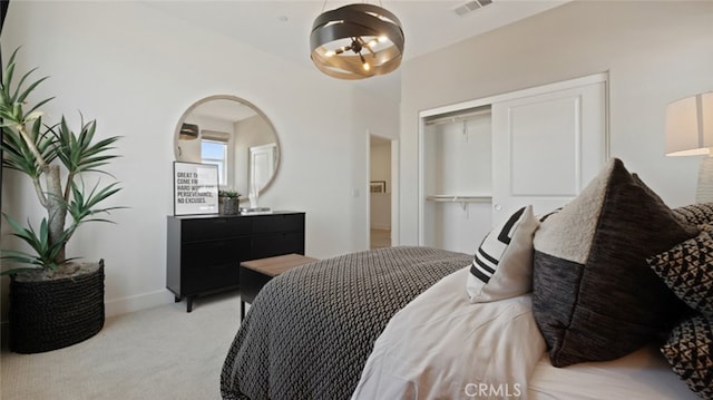 bedroom featuring visible vents, a closet, and light colored carpet
