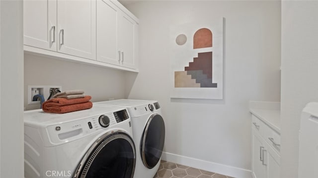 washroom with baseboards, cabinet space, and washing machine and clothes dryer