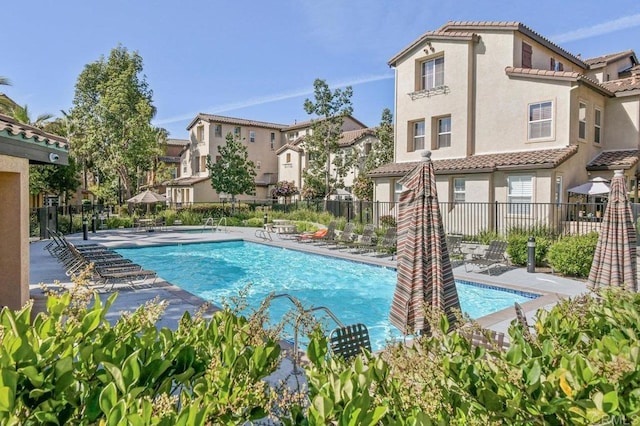 pool with fence, a residential view, and a patio area