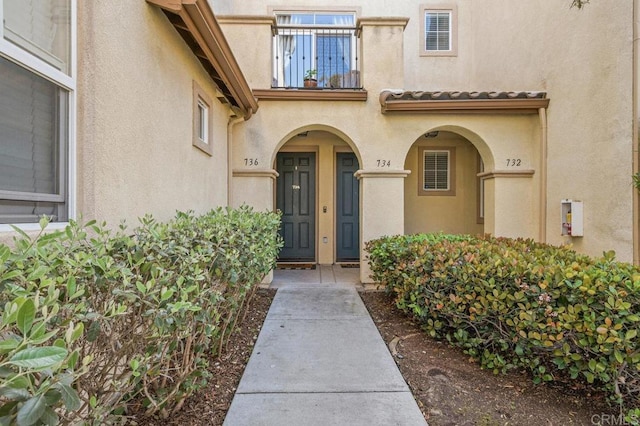 doorway to property featuring a balcony and stucco siding