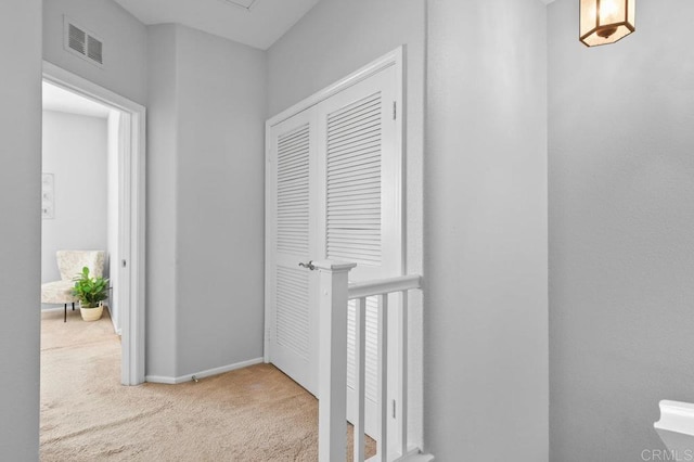 hallway featuring carpet flooring, baseboards, and visible vents