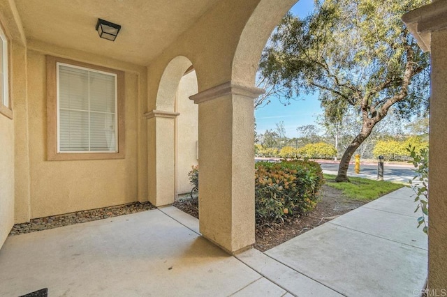 entrance to property with a patio and stucco siding