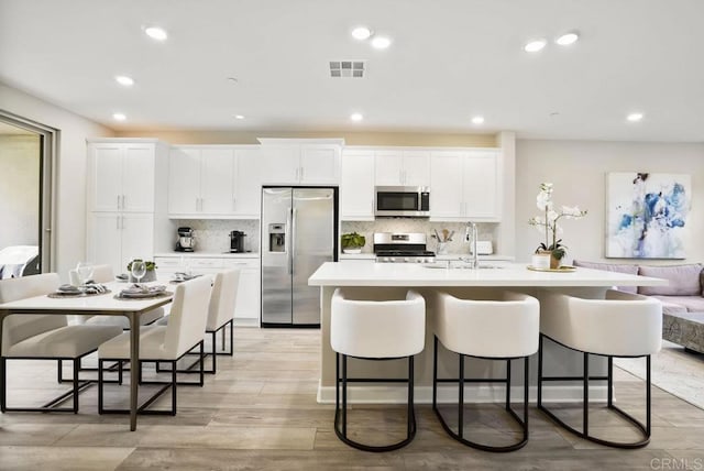16755 Coyote Bush Dr Unit 32, San Diego, CA 92127 - kitchen featuring appliances with stainless steel finishes, a sink, a center island with sink, a kitchen breakfast bar, and recessed lighting