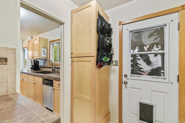 4580 60th St, San Diego, CA 92115 - kitchen featuring stainless steel dishwasher, a sink, light brown cabinetry, a textured wall, and dark countertops