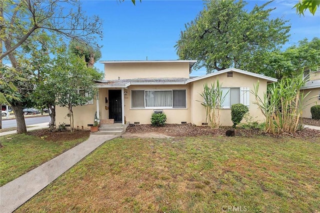 view of front of house with stucco siding and a front yard