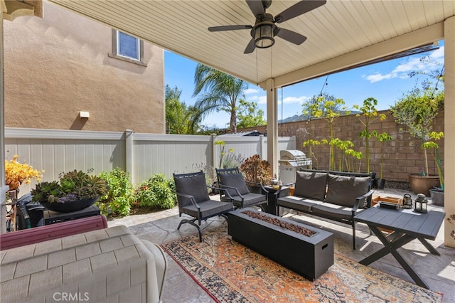 view of patio with a ceiling fan, a fenced backyard, and an outdoor living space with a fire pit