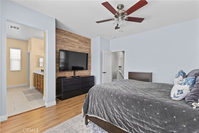 bedroom featuring light wood-style floors, baseboards, a ceiling fan, and visible vents