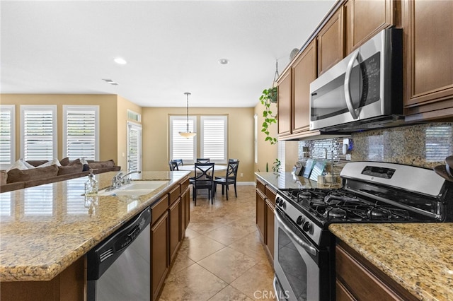 kitchen with baseboards, recessed lighting, a sink, backsplash, and stainless steel appliances