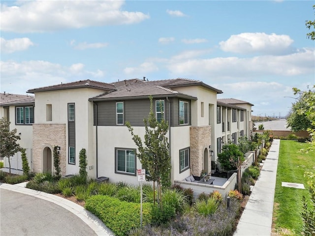 3860 S Oasis Paseo Unit 7, Ontario, CA 91761 - view of property exterior featuring stucco siding and stone siding
