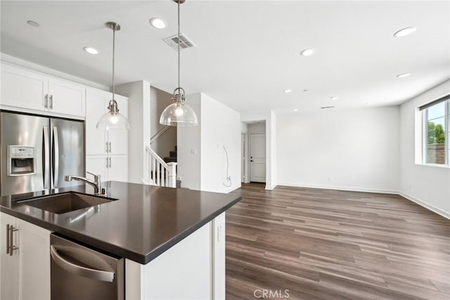3860 S Oasis Paseo Unit 7, Ontario, CA 91761 - kitchen featuring dark countertops, a sink, stainless steel appliances, open floor plan, and visible vents