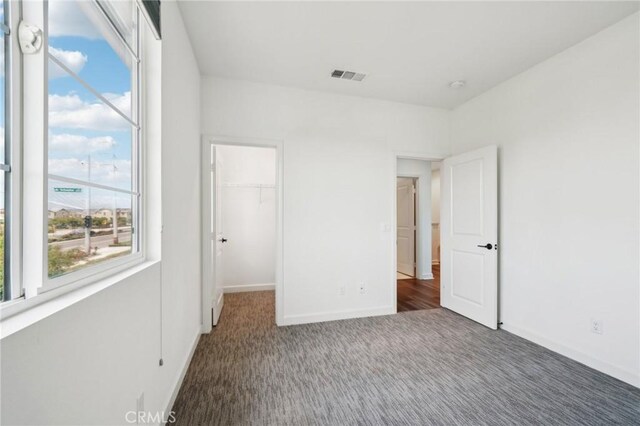 3860 S Oasis Paseo Unit 7, Ontario, CA 91761 - unfurnished bedroom with baseboards, visible vents, a spacious closet, and carpet