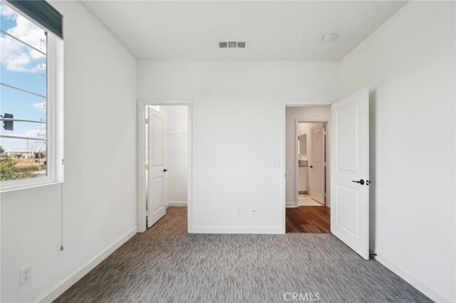 3860 S Oasis Paseo Unit 7, Ontario, CA 91761 - unfurnished bedroom featuring baseboards, carpet, a spacious closet, and visible vents