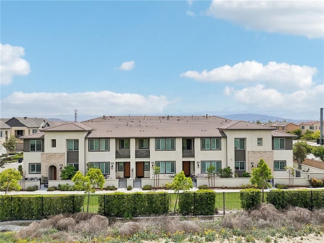 3860 S Oasis Paseo Unit 7, Ontario, CA 91761 - exterior space with a fenced front yard, stucco siding, stone siding, and a residential view