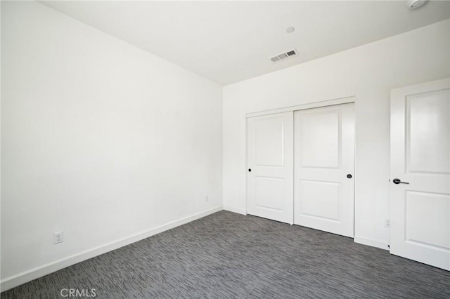 3860 S Oasis Paseo Unit 7, Ontario, CA 91761 - unfurnished bedroom featuring baseboards, a closet, dark colored carpet, and visible vents