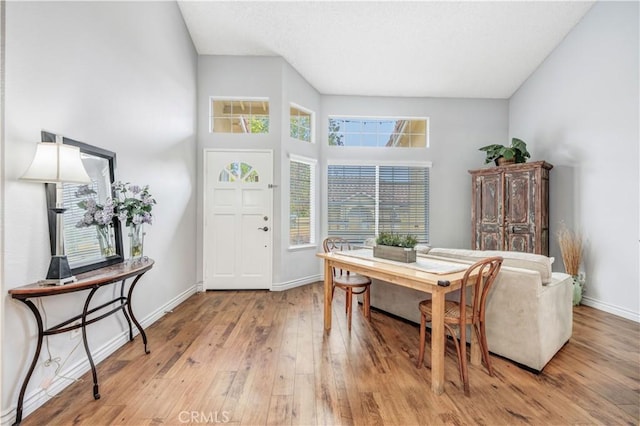 foyer entrance with baseboards and light wood-style flooring