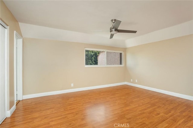 unfurnished room featuring baseboards, a ceiling fan, and light wood-type flooring