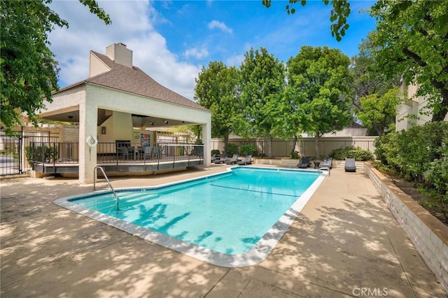 pool with a deck, fence, and a patio