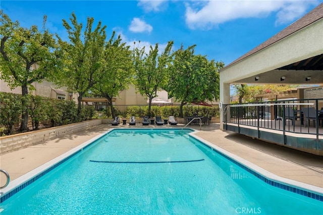 community pool featuring a patio and fence