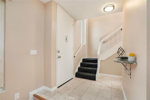 foyer with stairs and baseboards