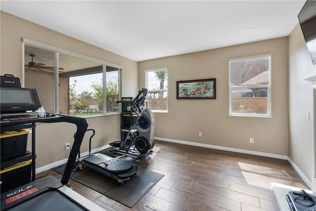 workout area featuring a ceiling fan, baseboards, and wood finished floors