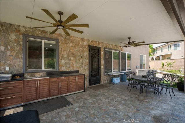 view of patio with area for grilling, ceiling fan, fence, and outdoor dining area