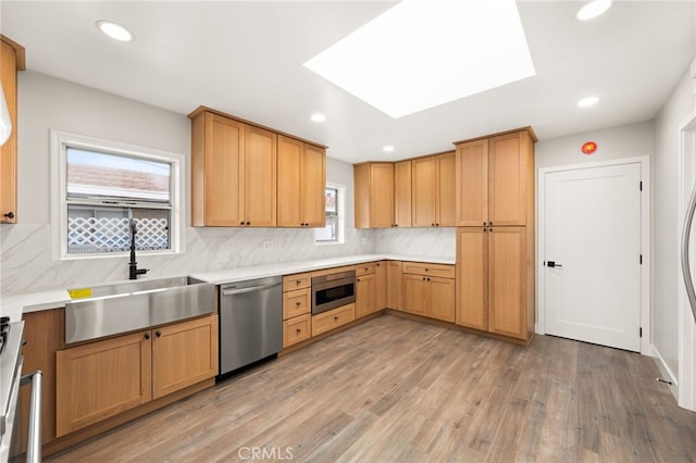 8392 Walker St, La Palma, CA 90623 - kitchen with stainless steel appliances, decorative backsplash, light wood-style floors, recessed lighting, and light countertops