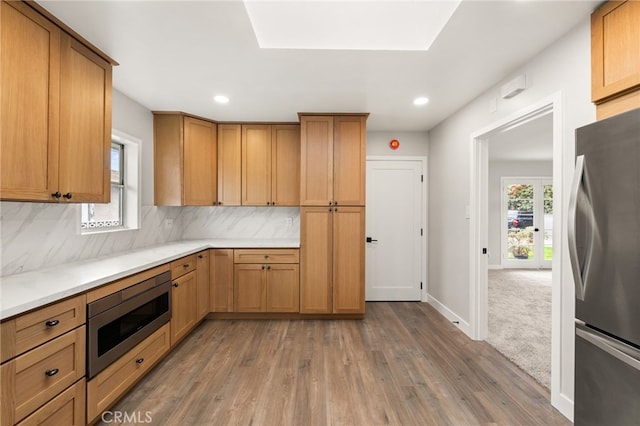 8392 Walker St, La Palma, CA 90623 - kitchen with appliances with stainless steel finishes, light wood-style floors, decorative backsplash, light countertops, and recessed lighting