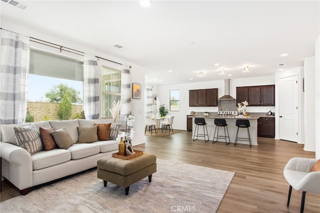 living room featuring light wood-style floors, recessed lighting, and visible vents