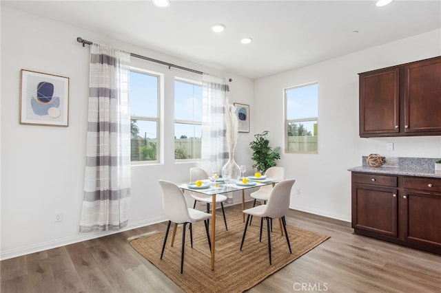 dining space with baseboards, recessed lighting, and light wood-style flooring