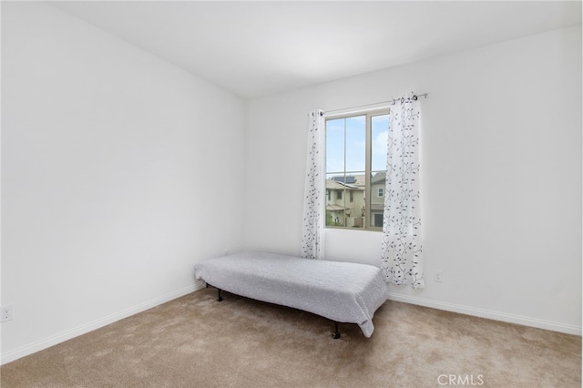 bedroom with baseboards and carpet
