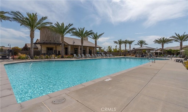community pool featuring fence, a patio, and a gazebo